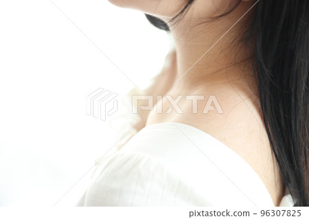 Close up of shoulder young Asian woman on bed relaxing in the morning light with white room Close up of shoulder young Asian woman on bed relaxing in the morning light with white room 96307825