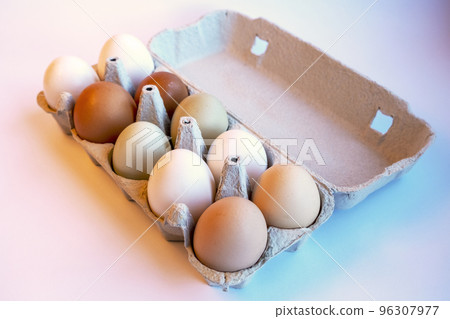 Assortment of different colored, fresh, chicken eggs. Light brown, white, dark brown and green. Recycled material egg container Assortment of different colored, fresh, chicken eggs. Light brown, white, dark brown and green. Recycled material egg container 96307977