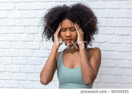 Woman suffering from headache desperate and stressed because pain and migraine. Hand on head. Woman suffering from headache desperate and stressed because pain and migraine. Hand on head. 96308485