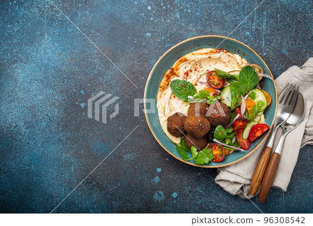 Middle Eastern Arab meal with fried falafel, hummus, vegetables salad space for text 96308542