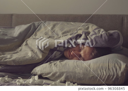 sick young man sleeps in bed 96308845