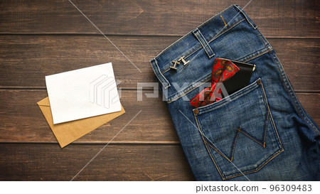 Men's party still Life with red bow tie on the Blue Jeans Wallet cufflinks envelope with paper for text. Flat lay, top view. Fathers day banner Men's party still Life with red bow tie on the Blue Jeans Wallet cufflinks envelope with paper for text. Flat lay, top view. Fathers day banner 96309483