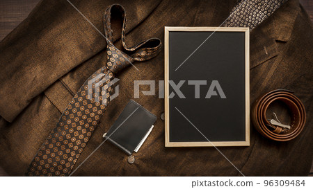 Men's necktie and accessories on Brown background with chalkboard with place for text. Men's necktie and accessories on Brown background with chalkboard with place for text. 96309484