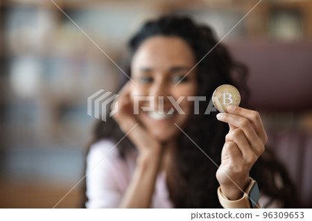 Woman showing Bitcoin golden coin, cryptocurrency concept Woman showing Bitcoin golden coin, cryptocurrency concept 96309653