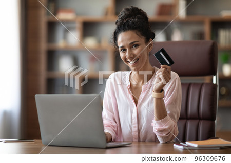 Attractive woman employee paying for goods and services on Internet 96309676