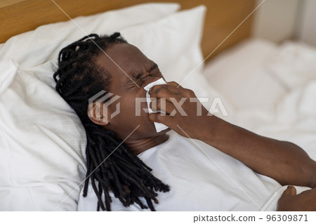 Closeup Shot Of Sick Black Man Blowing Runny Nose In Napkin Closeup Shot Of Sick Black Man Blowing Runny Nose In Napkin 96309871