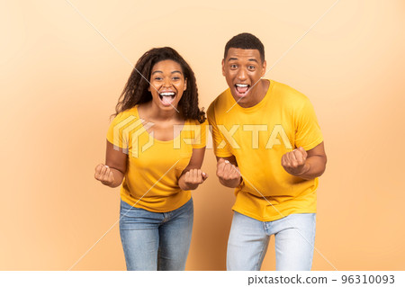 Hooray. Euphoric black spouses shaking clenched fists and exclaiming with excitement, celebrating success Hooray. Euphoric black spouses shaking clenched fists and exclaiming with excitement, celebrating success 96310093