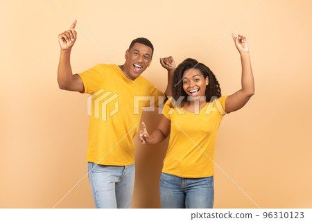 Excited young black couple dancing and enjoying favourite music, fooling around and having fun together 96310123