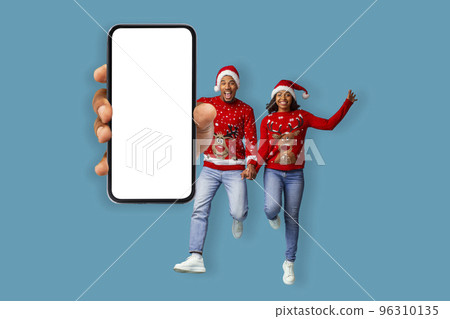 Cheerful black lovers celebrating Christmas, showing cell phone, mockup 96310135