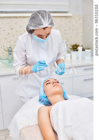 beautician applies the mask to face of beautiful woman 96310288