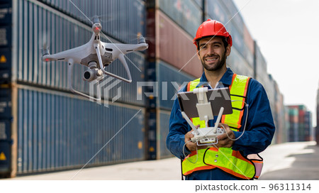 Foreman or worker use remote controller piloting drone at containers port for checking container.  96311314