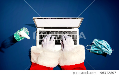 Santa Claus using a laptop computer with a mask and a sanitizer bottle Santa Claus using a laptop computer with a mask and a sanitizer bottle 96312807