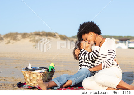 Happy African American family on picnic on beach Happy African American family on picnic on beach 96313146