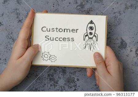 Woman holds card with words Customer success on concrete 96313177