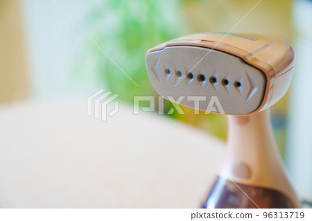 close up. Working portable hand steamer for clothes. steam for ironing clothes. 96313719