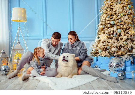 Happy family with dog and little daughter spend time together near Christmas tree in living room 96313889