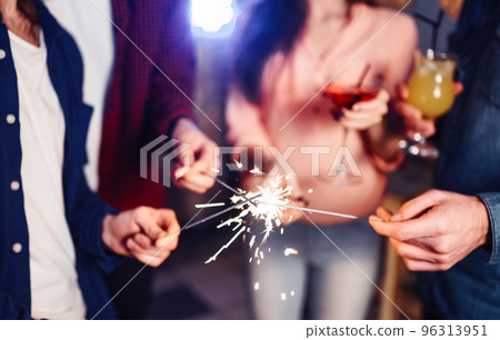 Group of friends having fun with sparklers. young people laugh. celebrating New Year together. 96313951
