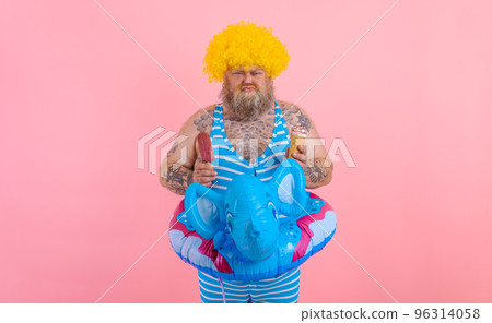 Fat man with beard and wig eats a popsicle and an icecream 96314058