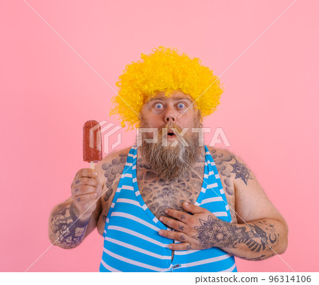 Fat amazed man with beard and wig eats a popsicle Fat amazed man with beard and wig eats a popsicle 96314106