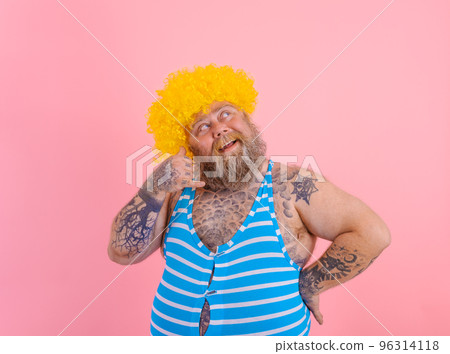Thoughtful man with yellow wig and swimsuit is ready to the summer 96314118