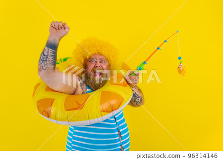 Fat happy man with wig in head plays with the fishing rod Fat happy man with wig in head plays with the fishing rod 96314146