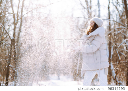 Happy woman in winter style clothes walking in the snowy park. Nature, holidays, travel concept. 96314293