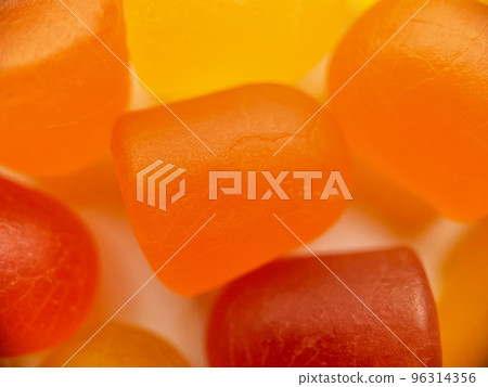 Close-up texture of orange and yellow multivitamin gummies on white background. Healthy lifestyle concept 96314356