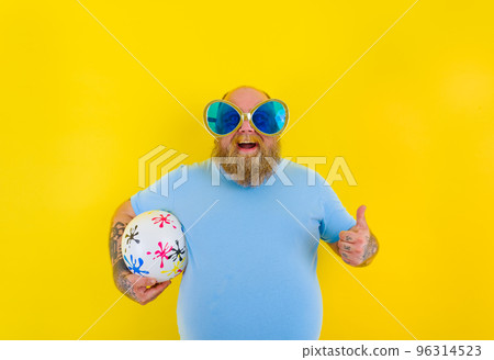 Fat man with beard and sunglasses have fun with a ball 96314523