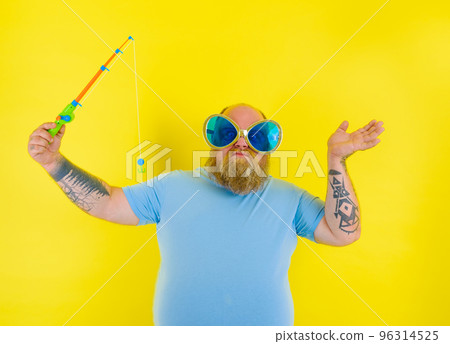 Fat man with beard and sunglasses is unhappy with the fishing rod 96314525