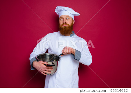 pensive chef with beard and red apron is ready to cook 96314612