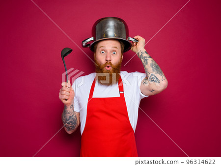 wondered chef with beard and red apron plays with pot 96314622