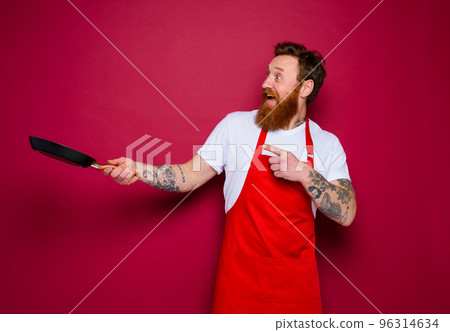 amazed chef with beard and red apron cooks with pan amazed chef with beard and red apron cooks with pan 96314634