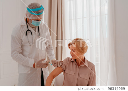 Doctor with mask and syringe is ready to administer the vaccine against covid 19 Doctor with mask and syringe is ready to administer the vaccine against covid 19 96314969