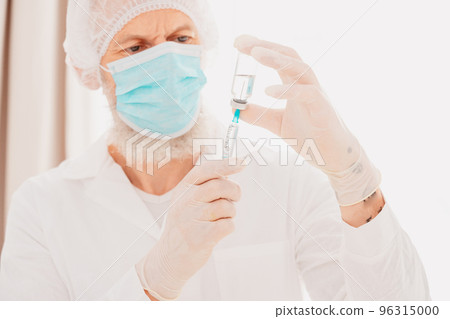 Doctor with syringe is ready to administer the vaccine against covid-19 96315000