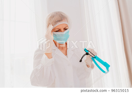 Doctor with face mask and face protector is tired about the covid-19 virus pandemic 96315015