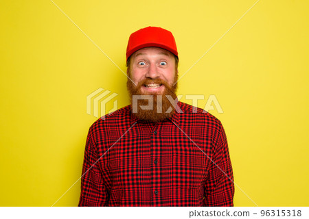 Delivery man with hat and beard has an happy expression Delivery man with hat and beard has an happy expression 96315318