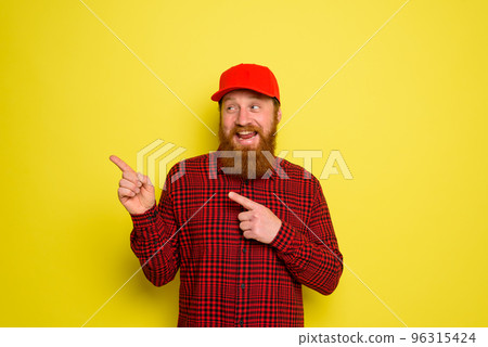 Happy delivery man with hat and beard indicates something Happy delivery man with hat and beard indicates something 96315424