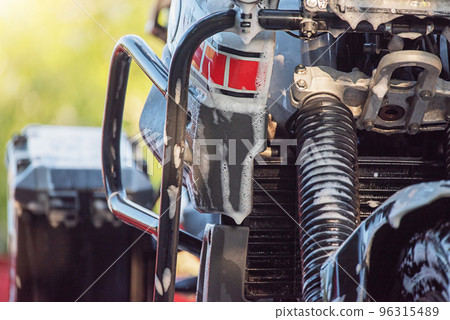 The process of washing a motorcycle on a sunny day. Enduro class wet motorcycle. The process of washing a motorcycle on a sunny day. Enduro class wet motorcycle. 96315489