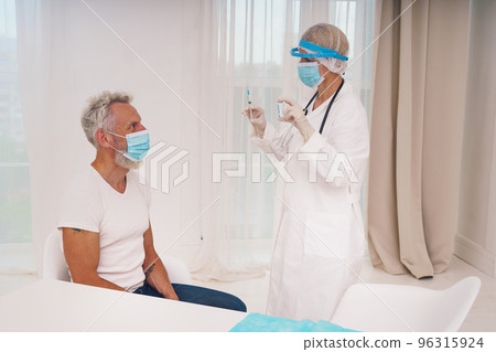Doctor with mask and syringe is ready to administer the vaccine against covid 19 96315924