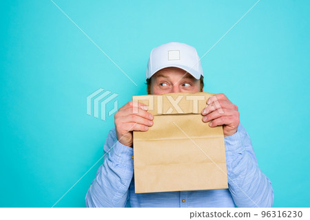 Delivery man hides his face with a food package Delivery man hides his face with a food package 96316230