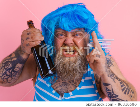 Fat man with beard and wig smokes cigarettes and drinks beer 96316590
