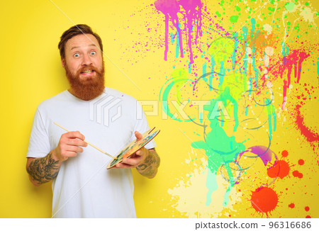 Doubter man with beard and tattoo is ready to draw with brushes 96316686