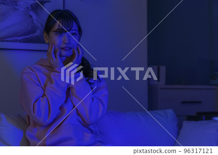 Young woman watching a horror movie 96317121