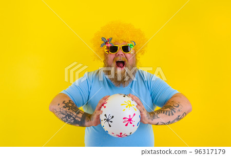 Fat man with wig in head and sunglasses have fun with a ball 96317179