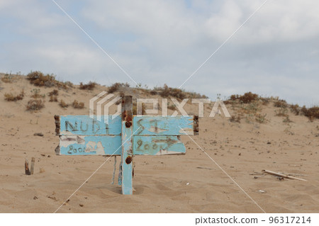 Information board on the beach with the sign nudist beach. Information about the nudist beach. Information board on the beach with the sign nudist beach. Information about the nudist beach. 96317214