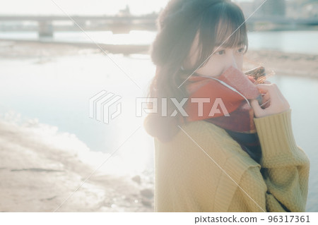 Photo of a young woman taking a walk while listening to music on the riverbed Photo of a young woman taking a walk while listening to music on the riverbed 96317361