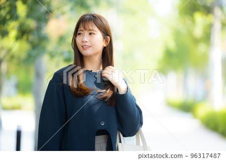 A woman in a coat walking outdoors A woman in a coat walking outdoors 96317487