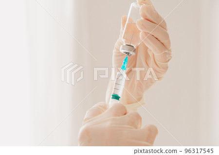 Doctor with syringe is ready to administer the vaccine against covid-19 Doctor with syringe is ready to administer the vaccine against covid-19 96317545