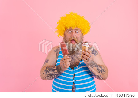 Fat man with beard and wig eats a popsicle and an icecream 96317586