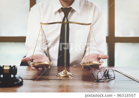 A judge or lawyer holds a scale of justice. 96318507